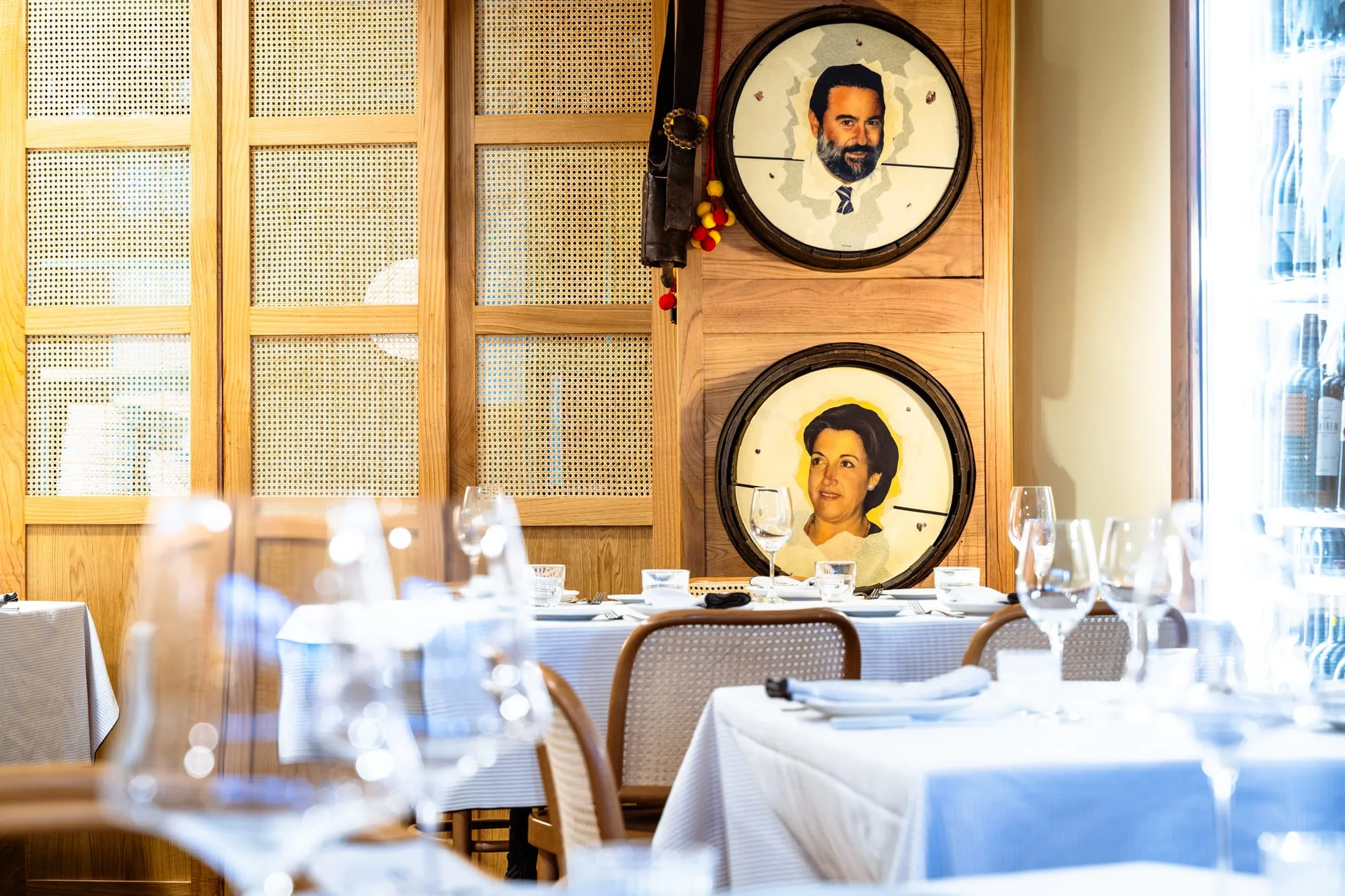 Comedor de la Abacería de la Sal con los retratos pintados de los fundadores en tapas de barril y las mesas con mantel blanco