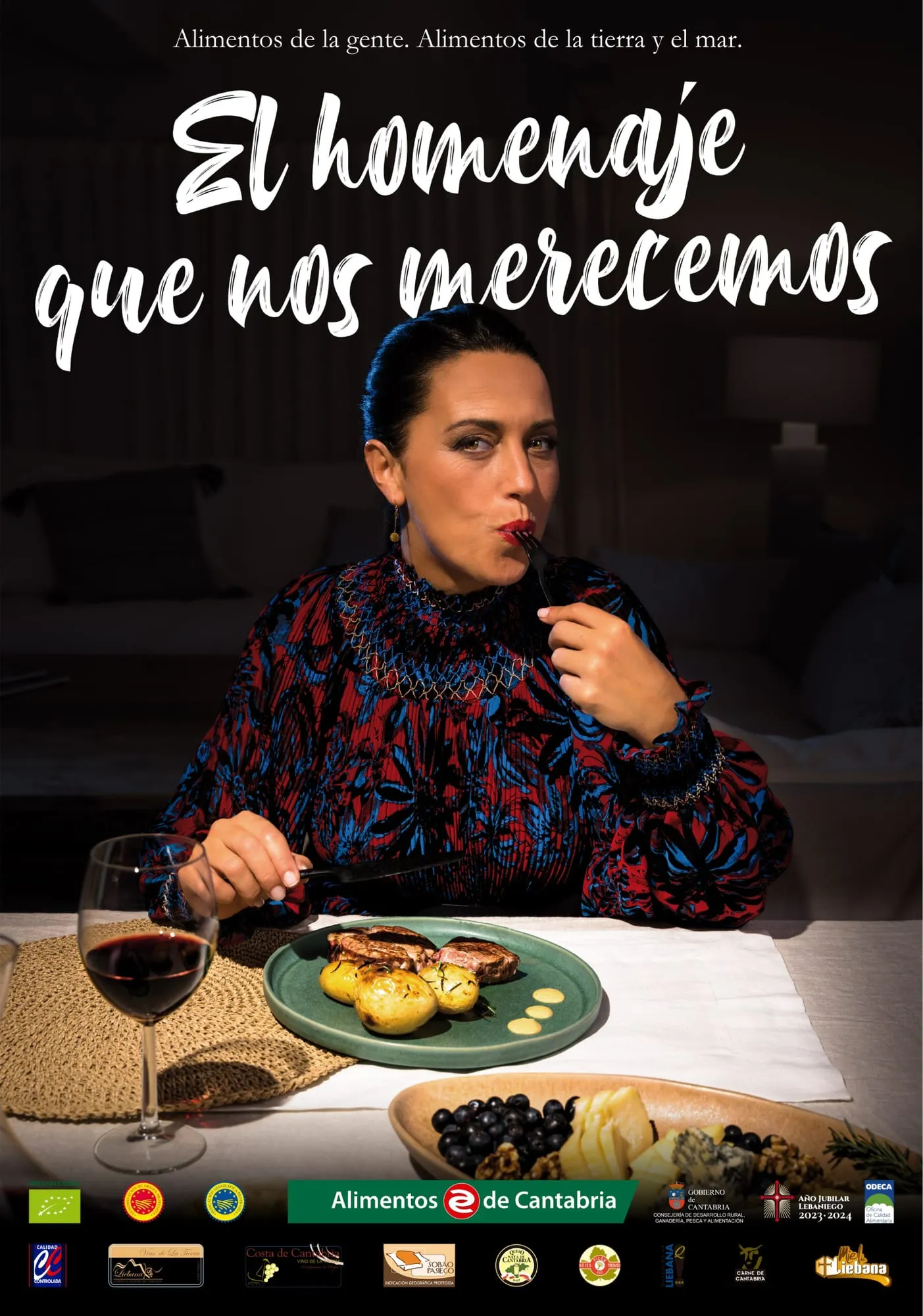 Cartel de la campaña: una mujer saborea un plato de carne con patatas junto a una copa de vino tinto, bajo el claim El homenaje que nos merecemos