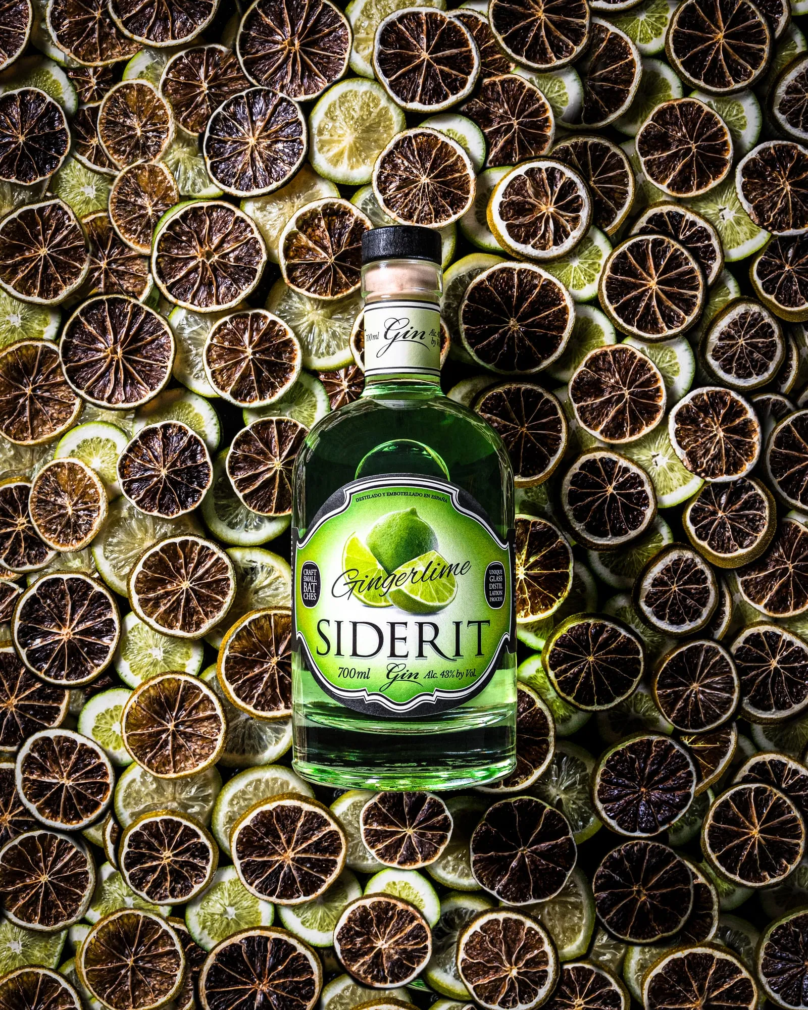 Botella de ginebra Siderit Gingerlime sobre un lecho de rodajas de lima deshidratada