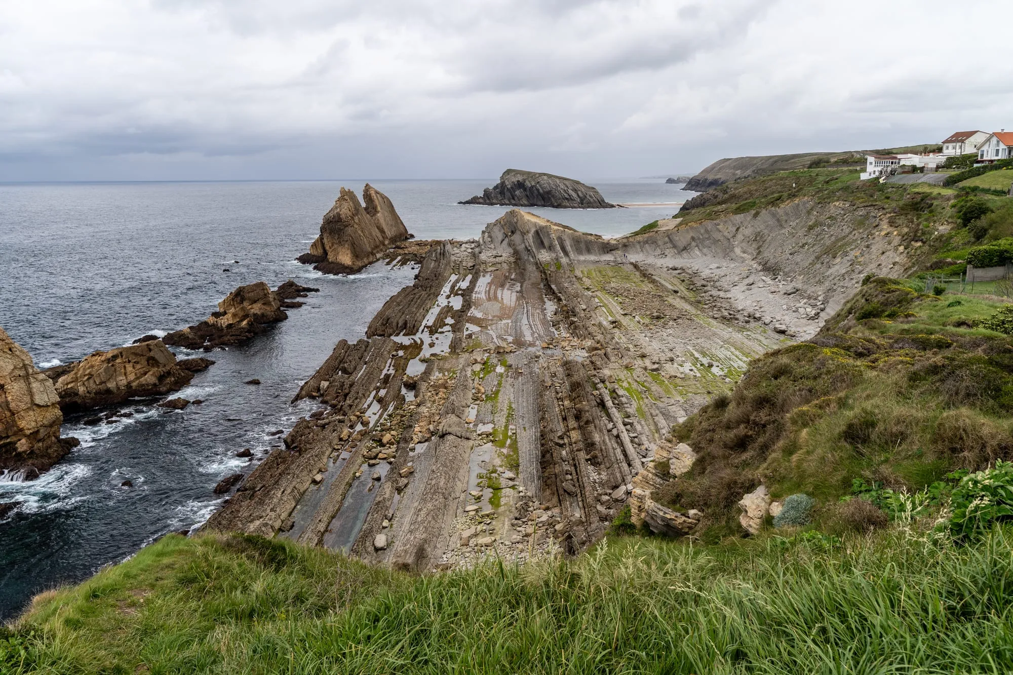 Acantilados y plataforma rocosa de la playa de la Arnía, en la Costa Quebrada, bajo un cielo cubierto