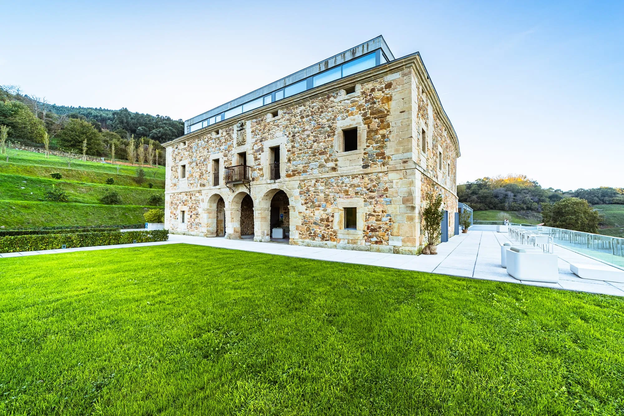 Casona de piedra del siglo XVII de Pico Velasco sobre el césped, con el valle al fondo
