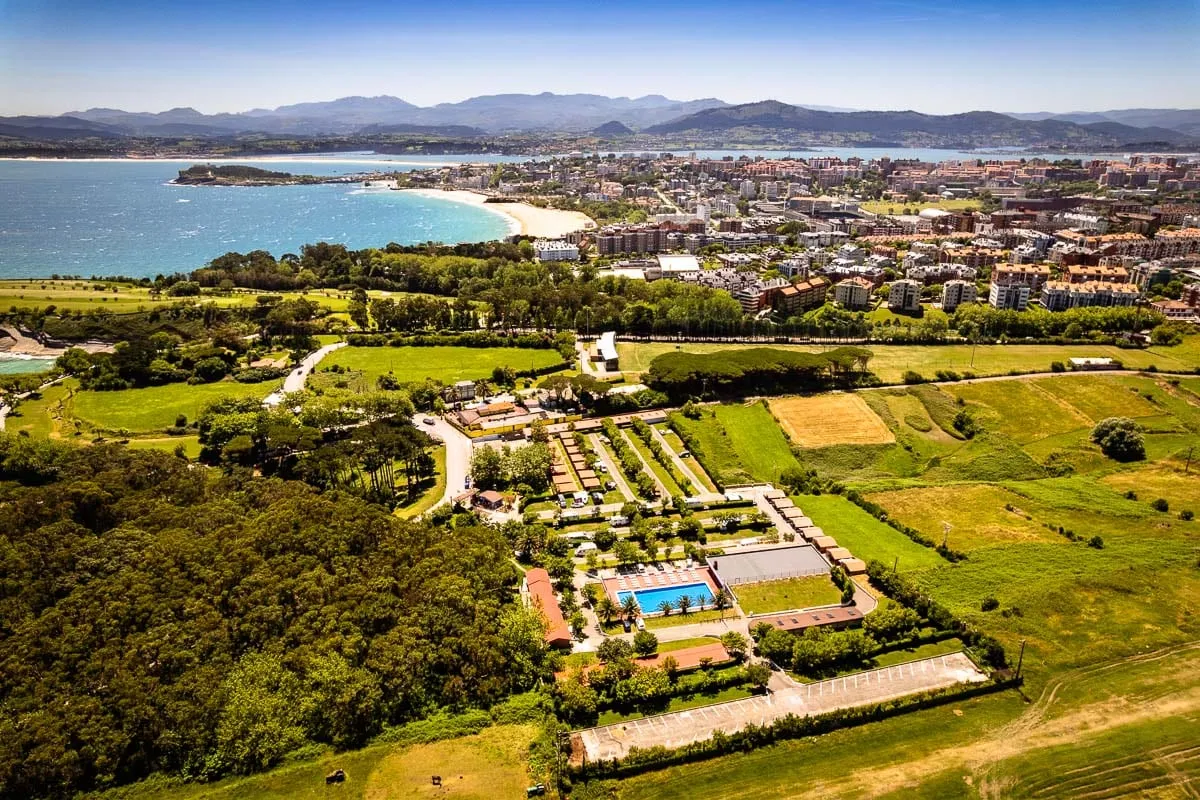 Vista aérea del Camping Cabo Mayor con la piscina, la bahía de Santander y la ciudad al fondo