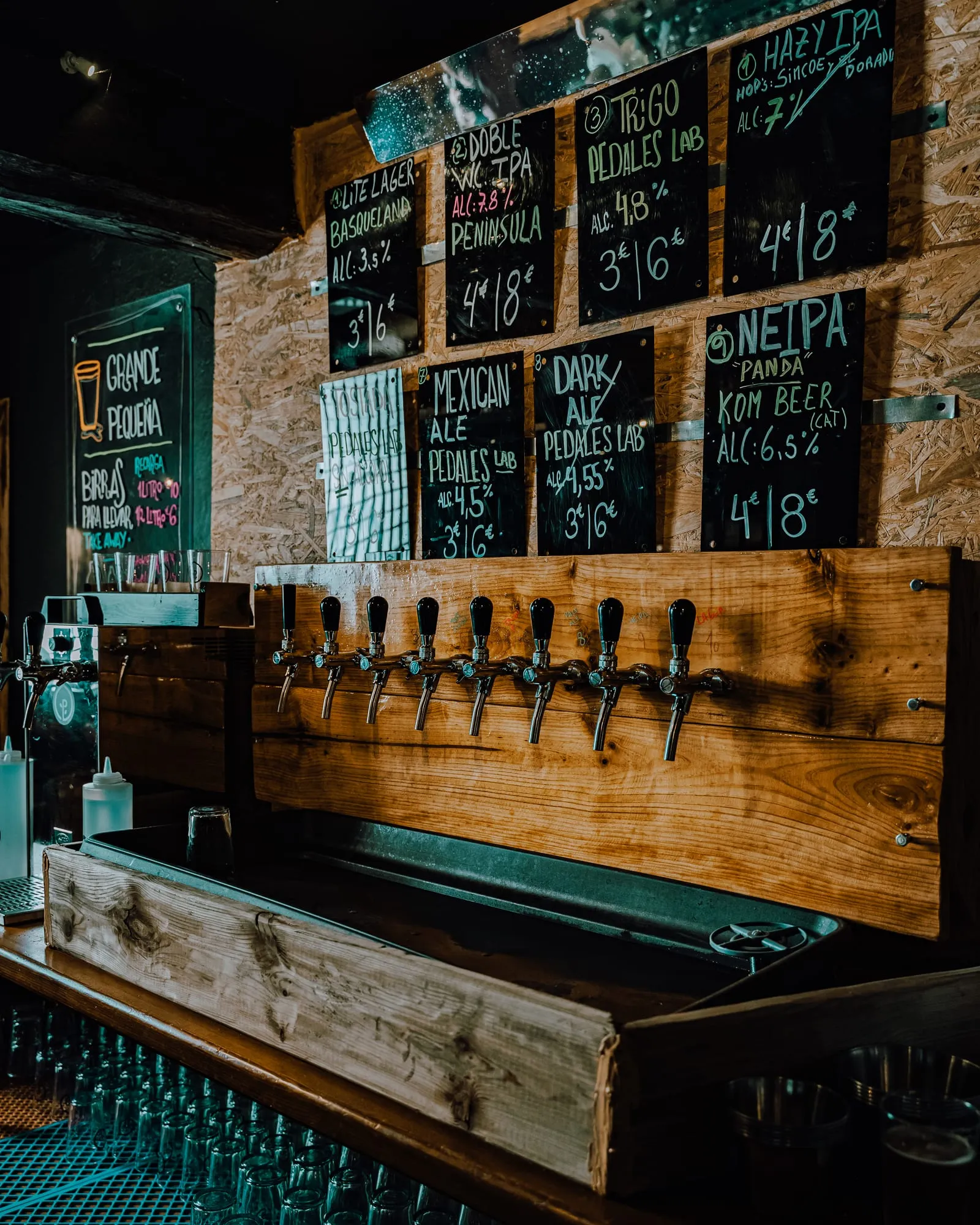 Pared de grifos con ocho tiradores y pizarras escritas a mano con las cervezas del día