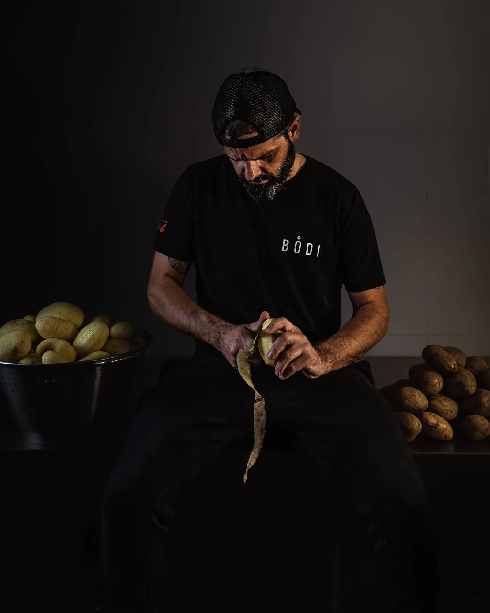 Cocinero de El Bodi pelando patatas a mano en la cocina