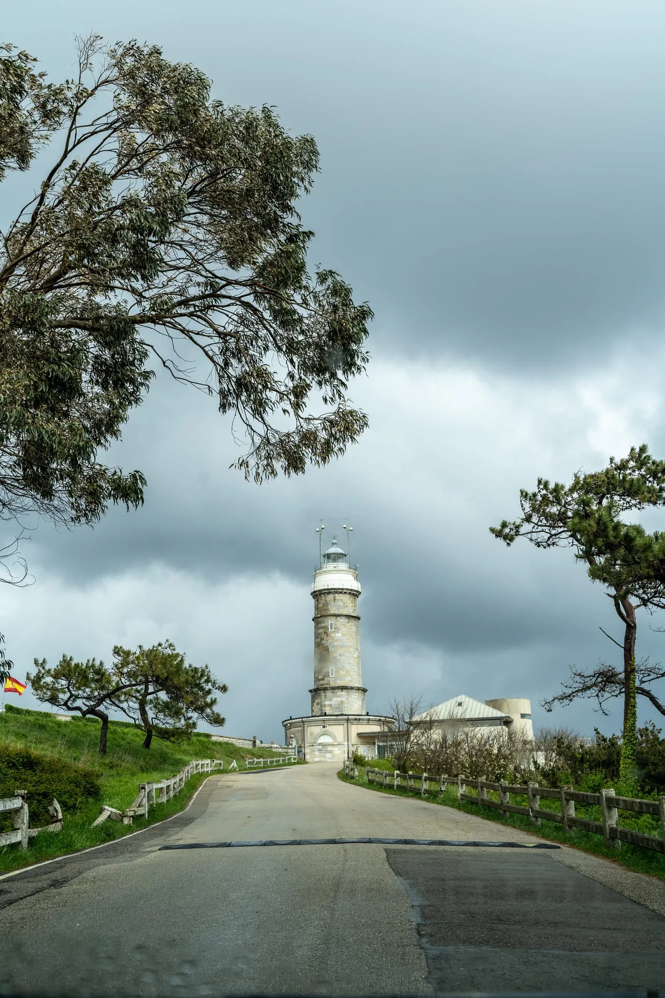 Carretera de acceso al faro de Cabo Mayor, en Santander, con nubes de tormenta y eucaliptos
