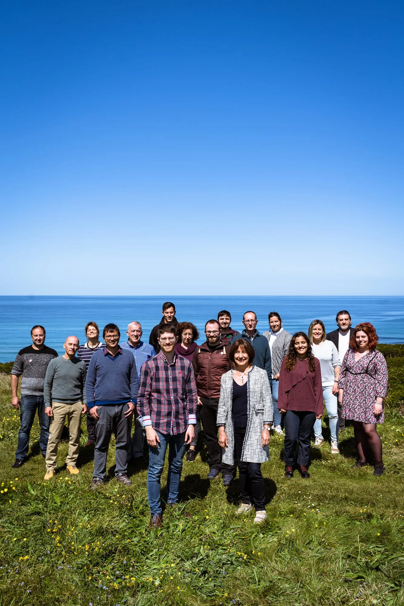 Grupo de candidatos de Cantabristas en un prado junto al mar bajo un cielo despejado
