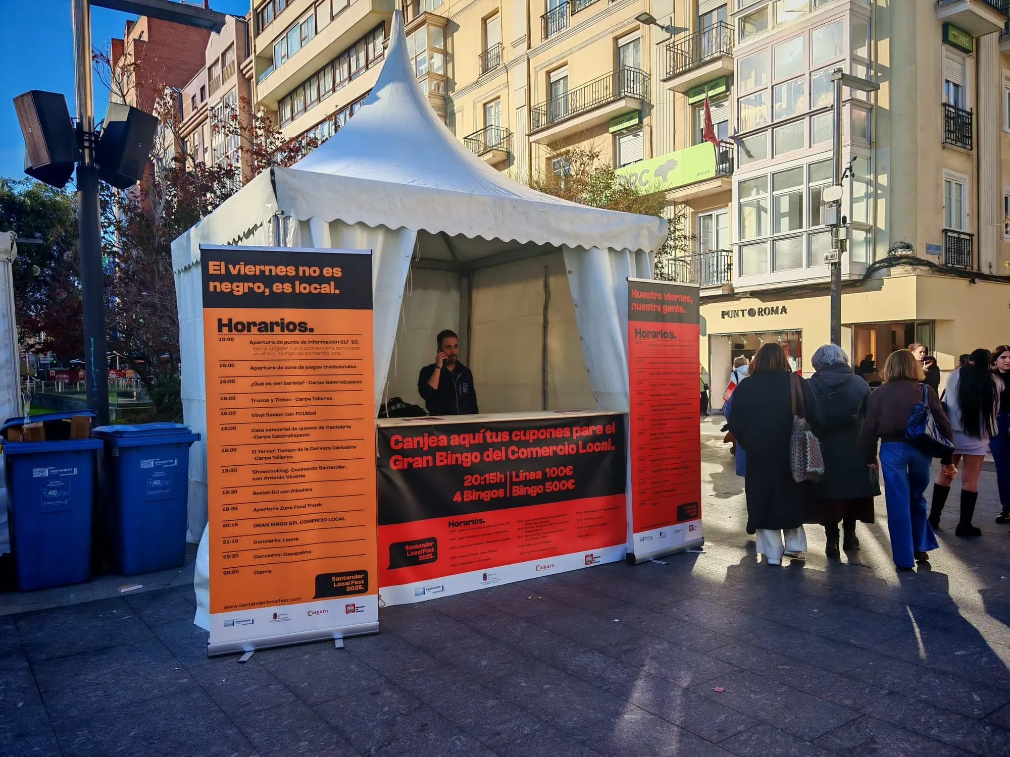 Punto de información del festival con los roll-ups del programa y el banner de canje de cupones para el bingo