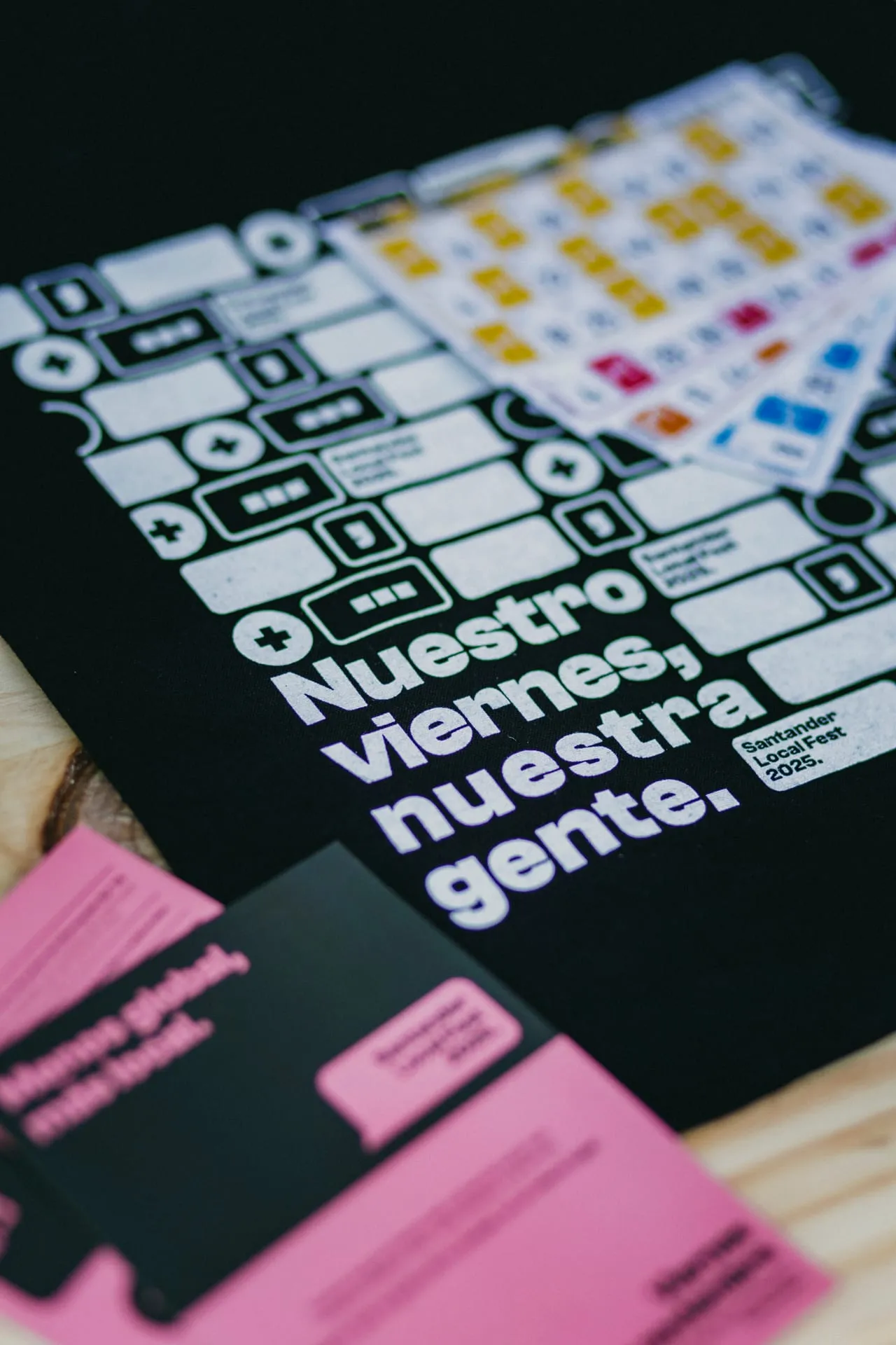 Totebag negra con el lema Nuestro viernes, nuestra gente junto a los cartones del bingo