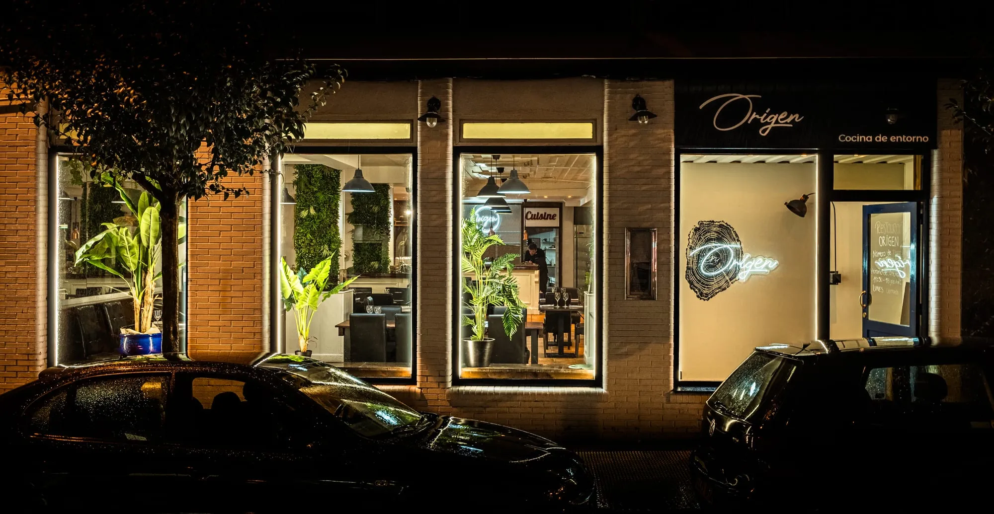 Fachada del restaurante de noche con el nuevo rótulo Origen, cocina de entorno, en Castro Urdiales