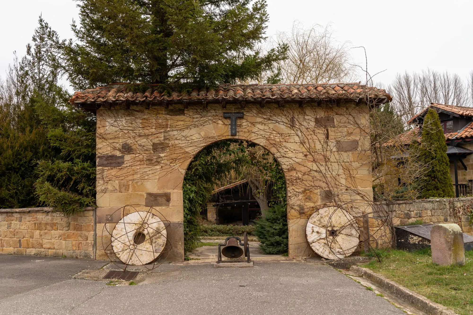 Portón de piedra del hotel Molino Tejada en Polientes, con dos ruedas de molino a los lados