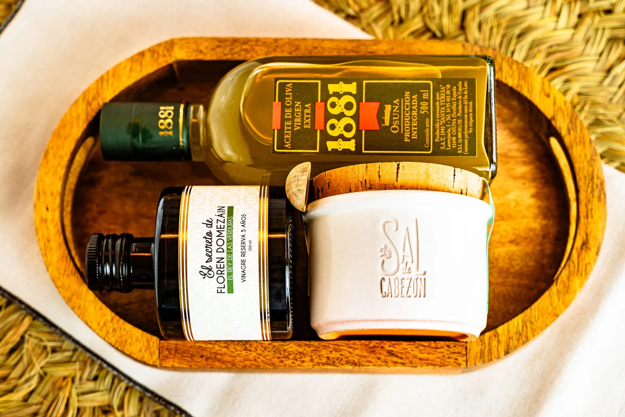 Bandeja de madera con aceite de oliva virgen extra, vinagre reserva y el tarro de Sal de Cabezón