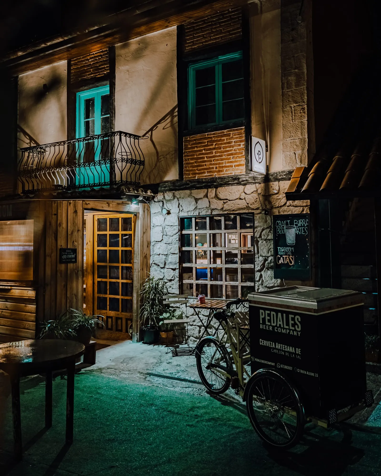 Entrada del local de noche con el triciclo de reparto rotulado con la marca