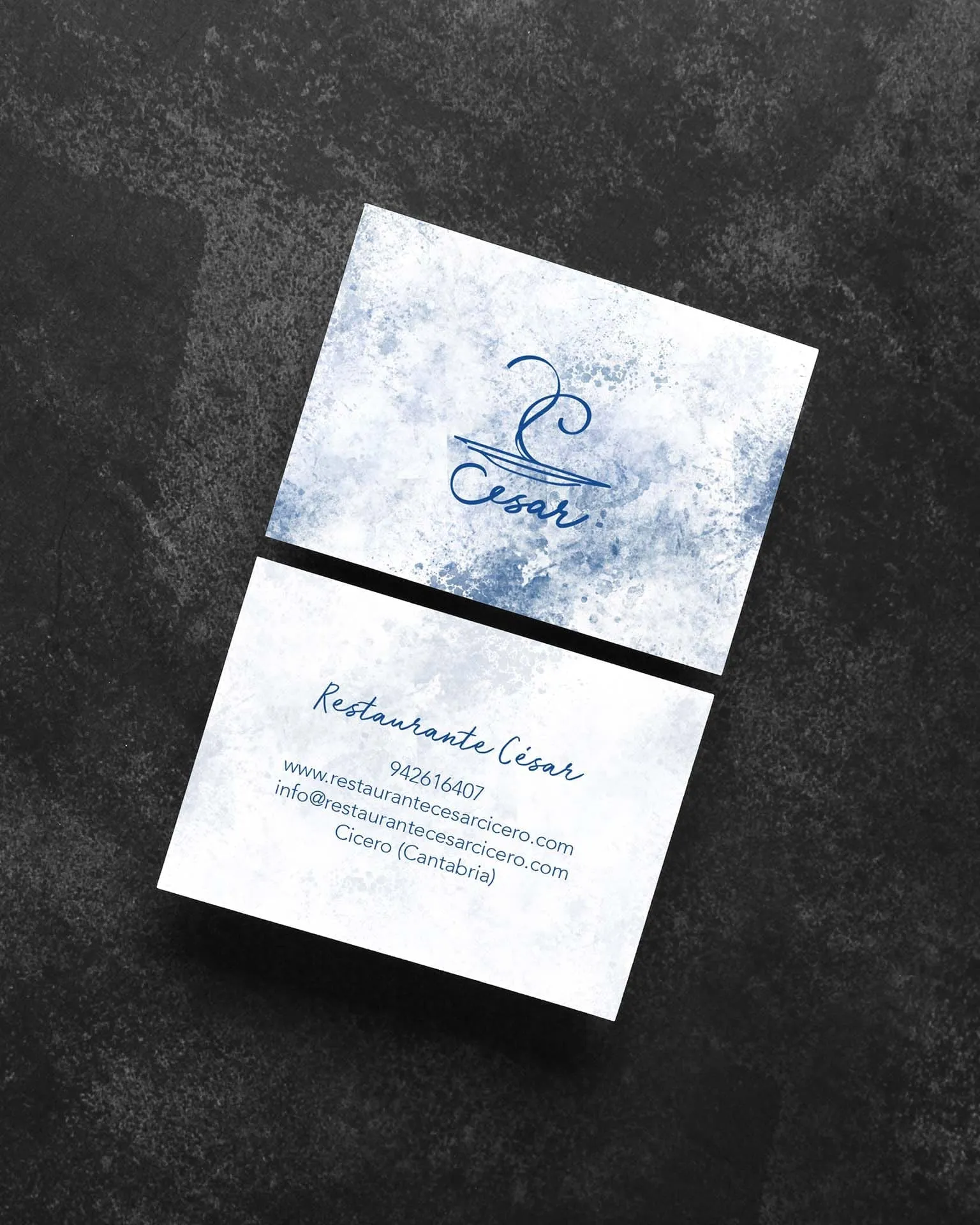 Tarjetas de visita del Restaurante César con el logotipo azul sobre textura de acuarela